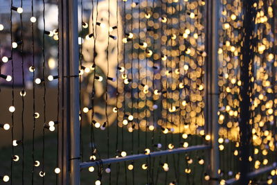 Full frame shot of illuminated light bulbs hanging at night