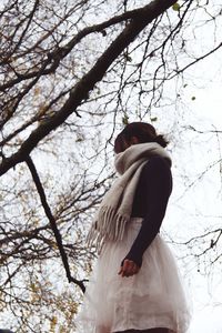 Rear view of woman standing on snow covered tree