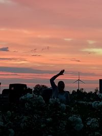 Silhouette man photographing at camera against sky during sunset