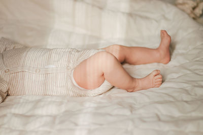 Low section of woman lying on bed