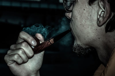 Cropped image of man smoking pipe