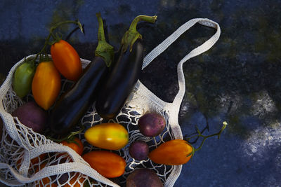 Harvest vegetables in eco shopping bag with colorful tomatoes, eggplants, purple potatoes