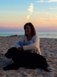 Rear view of woman sitting on beach