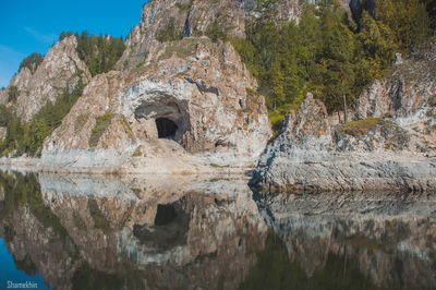 Reflection of mountain on cliff against sky