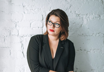 Portrait of a young woman against wall