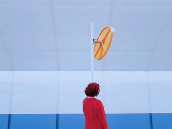 Rear view of woman standing against wall