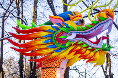 Low angle view of multi colored sculpture against trees