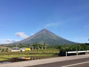 Road by mountain against blue sky