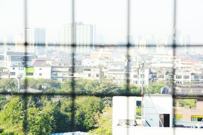 Close-up of cityscape against sky seen through window