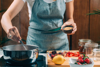 Fruit canning preservation. woman cooking fruits and making homemade jam.