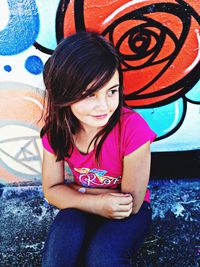Portrait of beautiful young woman sitting outdoors