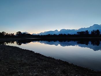 Scenic view of lake against clear sky during sunset