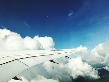 Low angle view of airplane wing against cloudy sky