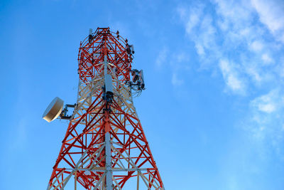 Low angle view of communications tower against blue sky