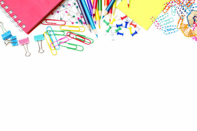 High angle view of multi colored pencils on white background