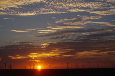 Low angle view of silhouette windmill against sky during sunset