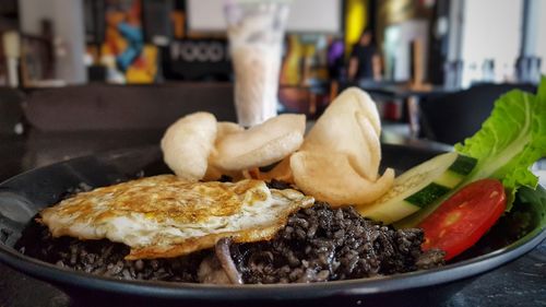 Close-up of squid's ink fried rice in plate on table