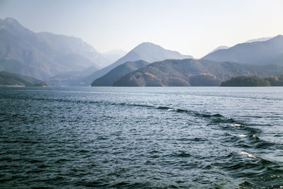 Scenic view of river and mountains against clear sky