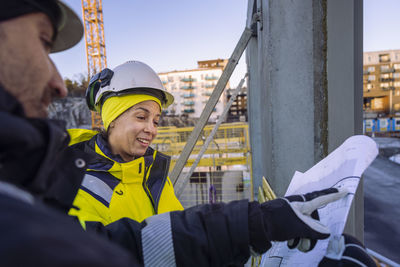 Two engineers looking at blueprints at construction site