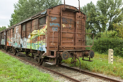 Train by railroad tracks against sky