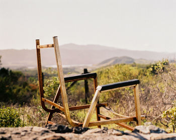 Chair on field against sky