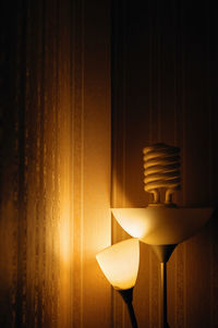 Close-up of illuminated lamp against wall