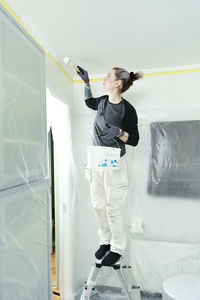 Woman painting ceiling