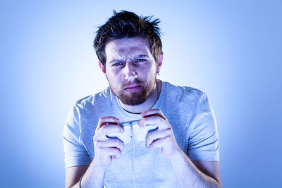 Portrait of young man against blue background