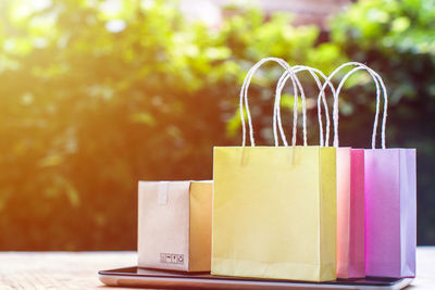 Close-up of shopping bags and mobile phone on table