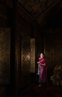 Woman in traditional clothing standing at temple