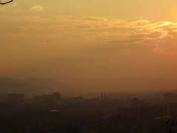 Silhouette cityscape against sky during sunset