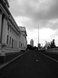 Road in city against cloudy sky