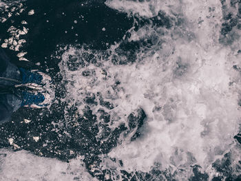 Low section of person standing in sea