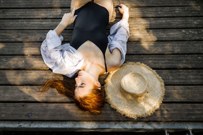 Rear view of woman sitting on boardwalk