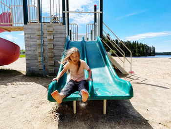 Full length of girl on slide at playground