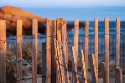 Close-up of fence by sea against sky