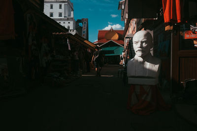 Statue by street against buildings in city