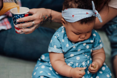 Midsection of mother with baby sitting