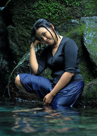 Young woman sitting in lake