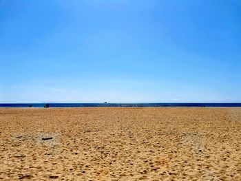 Scenic view of beach against clear blue sky