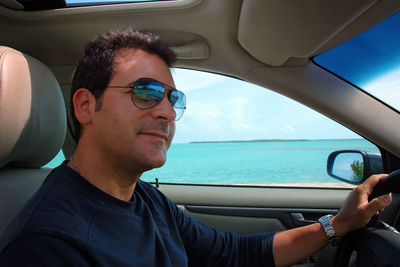 Portrait of man driving car against sea