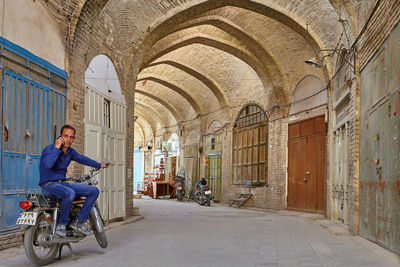 Woman riding bicycle on street amidst buildings