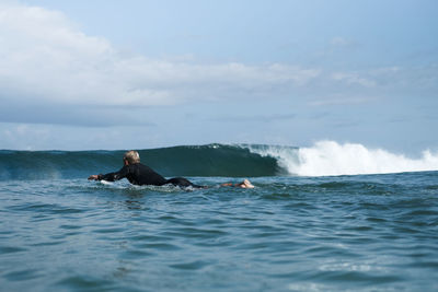 Man surfing in sea against sky