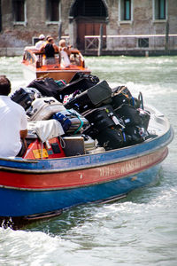 Rear view of man with luggage in boat sailing on canal