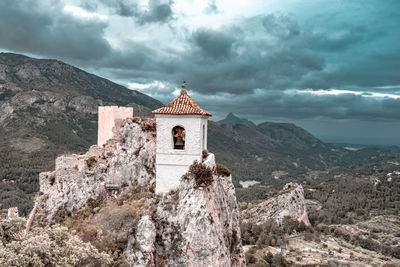 Traditional building by mountains against sky