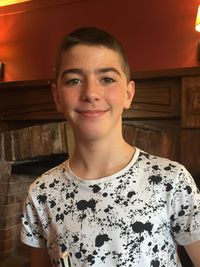 Portrait of smiling young man standing at home