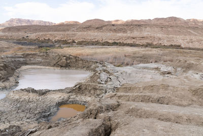 Sinkhole filled with turquoise water, near dead sea coastline. hole formed when underground salt is