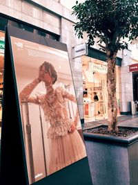 Woman standing by glass building