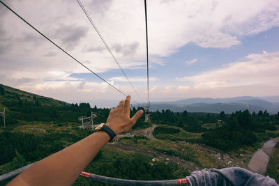 Low angle view of hand holding mountain against sky
