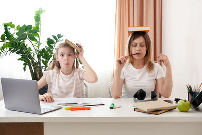 Mother helping daughter with homework